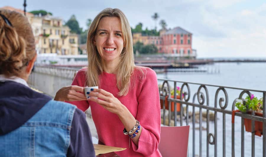 Foto von Elise, die in einem Café sitzt. Sie verwendet Luja female, um ihre mit MS verbundenen Blasensymptome zu behandeln.