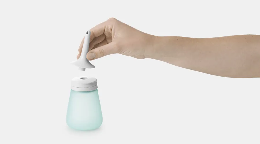 Bild von Peristeen Light 250 ml. Eine Hand hält den vorgeschmierten Katheter von Peristeen Light. 