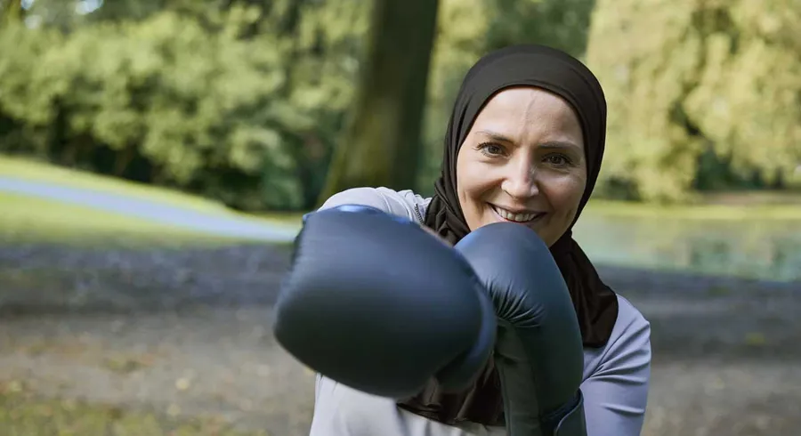 Bild von Fikria draußen mit Boxhandschuhen. Fikria verwendet Peristeen® Light. 