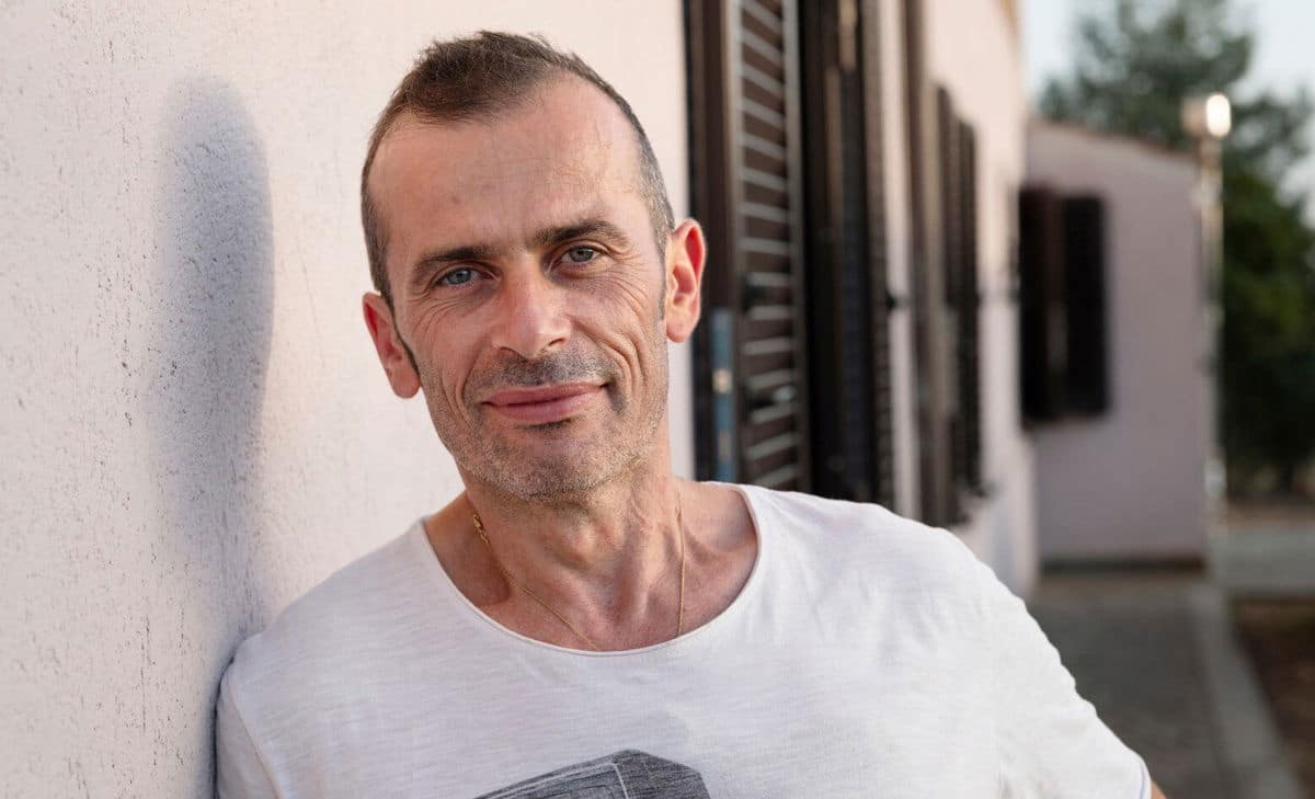 Porträtfoto von Andrea vor seinem Haus. Andrea lebt mit MS und wünscht sich, er hätte etwas mehr über die damit verbundenen Blasen- und Darmprobleme gewusst.