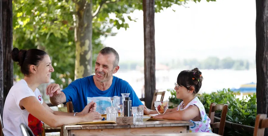 Andrea sitzt mit seiner Familie an einem Restauranttisch. Wenn Sie Fragen oder Bedenken bezüglich Ihrer Blase und Ihres Darms im Zusammenhang mit MS haben, wenden Sie sich an Coloplast, um Unterstützung zu erhalten.  