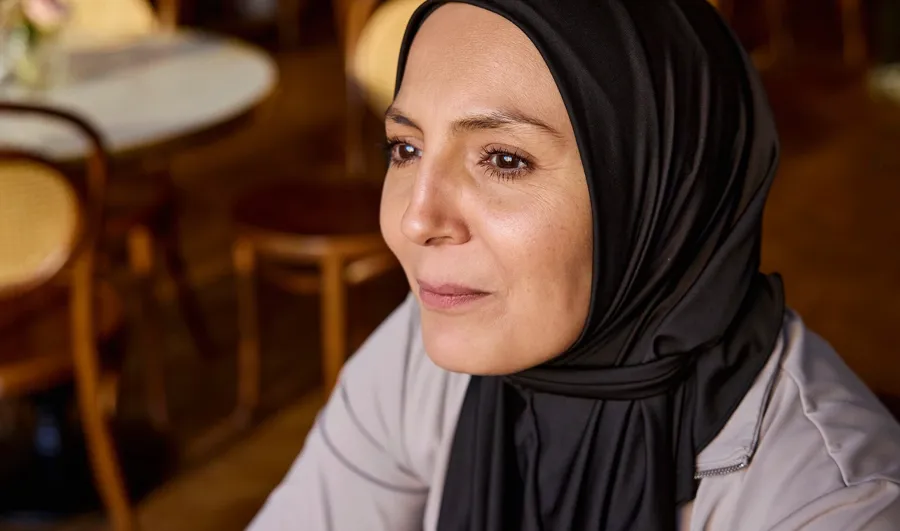 Foto von Fikra in einem Café. Fikrias Darmprobleme sind größtenteils auf ihre MS zurückzuführen und beeinträchtigten ihre Lebensqualität erheblich. 