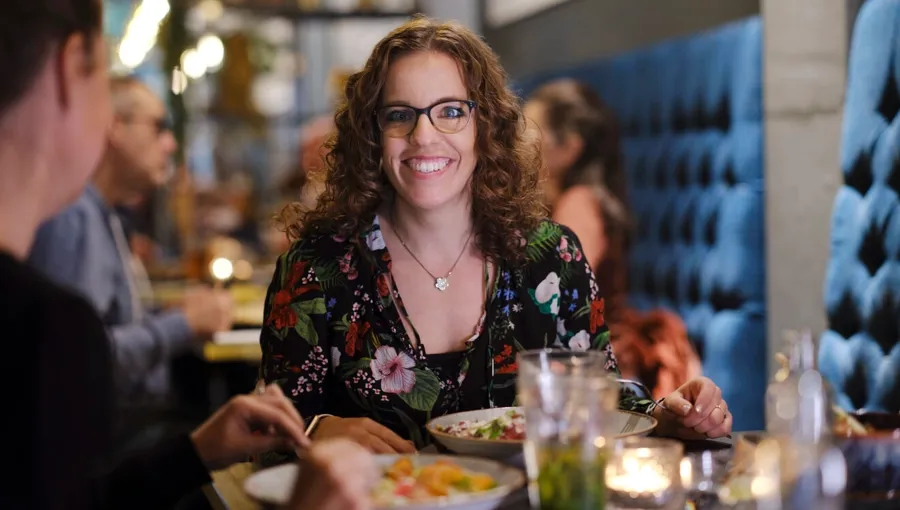 Foto von Marianne beim Essen mit Freunden. Marianne hat ein gutes Unterstützungsnetzwerk aus Freunden, die ihr helfen. 