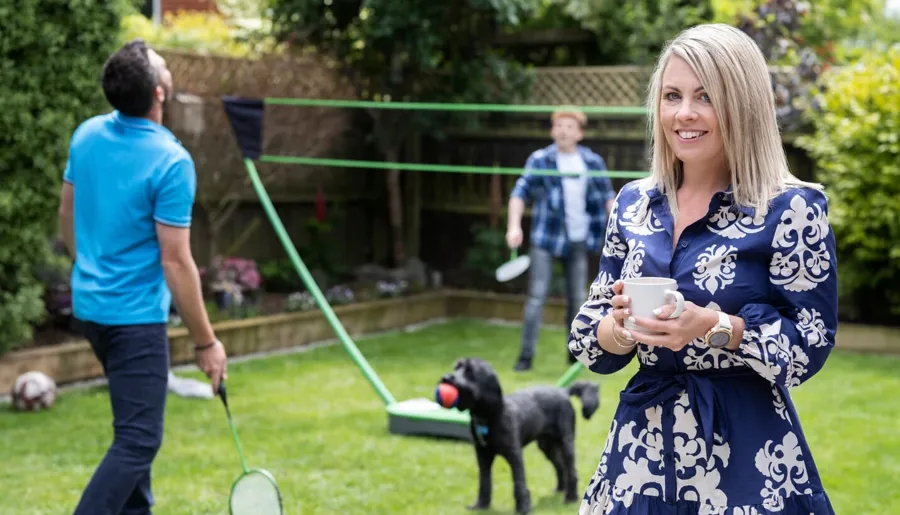 Laura steht in ihrem Garten. Als Laura mit dem Katheterisieren begann, gelang es ihr schnell, eine Routine zu entwickeln. 