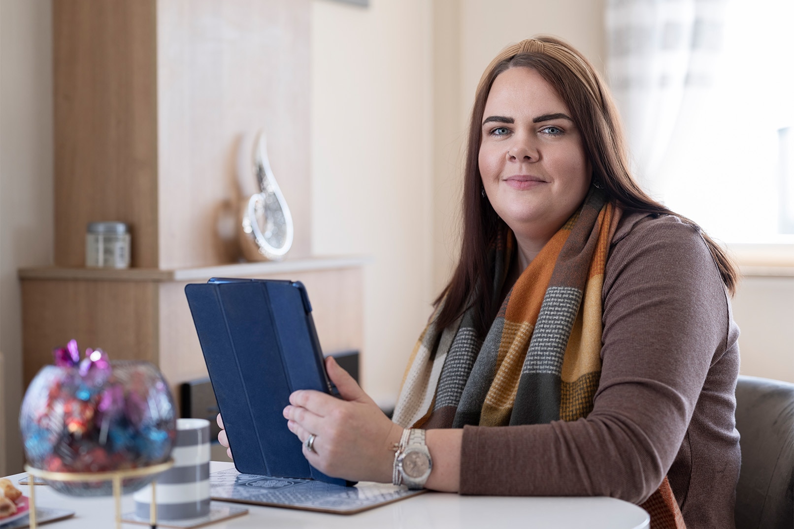 Sarah sits at her table. It was 4 years after Sarah’s initial diagnosis that she linked her bladder issues to her MS.